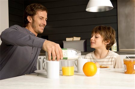 simsearch:6108-05864945,k - Mid adult man having breakfast with his son in the kitchen Stock Photo - Premium Royalty-Free, Code: 6108-05859875