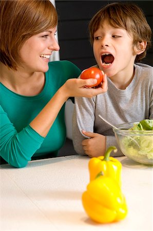 simsearch:6108-05860153,k - Young woman feeding a tomato to her son Stock Photo - Premium Royalty-Free, Code: 6108-05859884