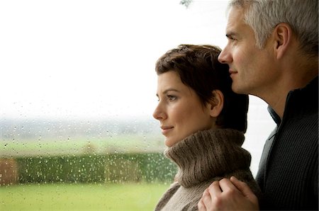 simsearch:6108-05859747,k - Mature man and a mid adult woman looking out through a window Stock Photo - Premium Royalty-Free, Code: 6108-05859941