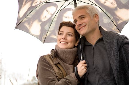 simsearch:6108-05859747,k - Close-up of a mid adult woman and a mature man under an umbrella Stock Photo - Premium Royalty-Free, Code: 6108-05859909