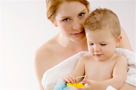 simsearch:6108-05860153,k - Portrait of a young woman wrapping her son in a towel and smiling Stock Photo - Premium Royalty-Free, Code: 6108-05860144