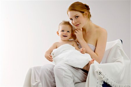 emotional images of mother holding baby - Portrait of a young woman wrapping her son in a towel and smiling Stock Photo - Premium Royalty-Free, Code: 6108-05860171