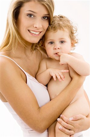 simsearch:6108-05860153,k - Portrait of a young woman carrying her son and smiling Stock Photo - Premium Royalty-Free, Code: 6108-05860181