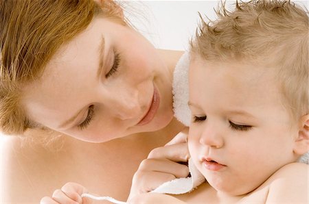 simsearch:6108-05860153,k - Close-up of a young woman wrapping her son in a towel and smiling Stock Photo - Premium Royalty-Free, Code: 6108-05860186