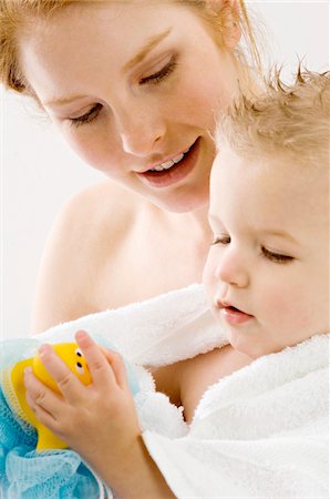 simsearch:6108-05860153,k - Close-up of a young woman wrapping her son in a towel and smiling Stock Photo - Premium Royalty-Free, Code: 6108-05860190