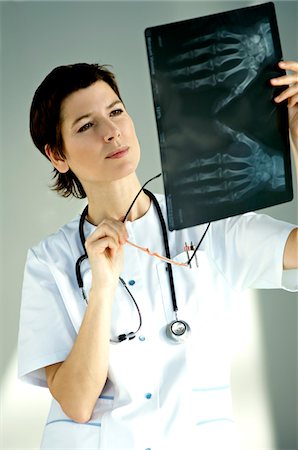 Female doctor examining an X-Ray report Stock Photo - Premium Royalty-Free, Code: 6108-05860314