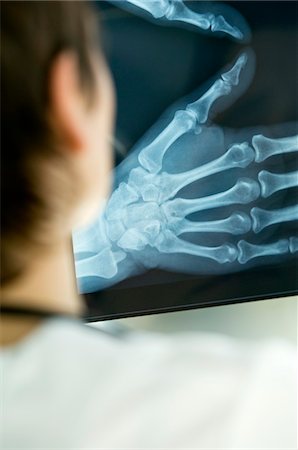 Rear view of a female doctor examining an X-Ray report Stock Photo - Premium Royalty-Free, Code: 6108-05860326