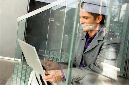 simsearch:6108-05860448,k - Businessman sitting on a staircase and using a laptop Foto de stock - Sin royalties Premium, Código: 6108-05860455