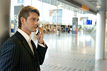 simsearch:6108-05860554,k - Side profile of a businessman talking on a mobile phone at an airport Stock Photo - Premium Royalty-Free, Code: 6108-05860483