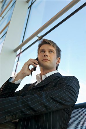 simsearch:6108-05860554,k - Low angle view of a businessman talking on a mobile phone Stock Photo - Premium Royalty-Free, Code: 6108-05860489