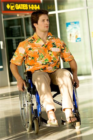 simsearch:6108-05860554,k - Mid adult man sitting in a wheelchair at an airport Stock Photo - Premium Royalty-Free, Code: 6108-05860417