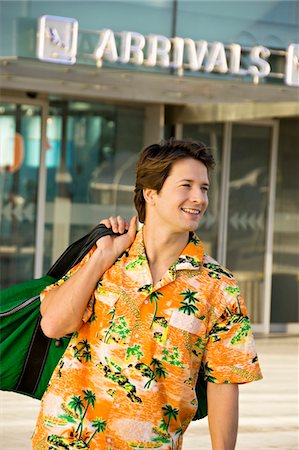 simsearch:6108-05860448,k - Mid adult man carrying his luggage outside an airport Foto de stock - Sin royalties Premium, Código: 6108-05860541