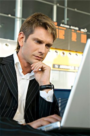 simsearch:6108-05860554,k - Businessman using a laptop in at an airport lounge Stock Photo - Premium Royalty-Free, Code: 6108-05860561