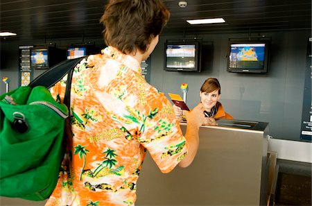 simsearch:6108-05860448,k - Female airline check-in attendant giving a passport and boarding pass to a passenger Foto de stock - Sin royalties Premium, Código: 6108-05860569