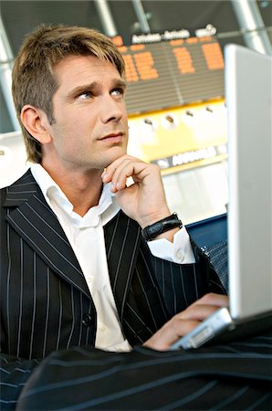 simsearch:6108-05860554,k - Businessman using a laptop at an airport lounge Stock Photo - Premium Royalty-Free, Code: 6108-05860570