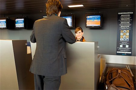 simsearch:6108-05860448,k - Rear view of a businessman standing at an airport check-in counter Foto de stock - Sin royalties Premium, Código: 6108-05860525