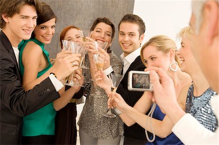 simsearch:6108-07969525,k - Mature man taking a picture of a group of people toasting with wine glasses in a party Stock Photo - Premium Royalty-Free, Code: 6108-05860652
