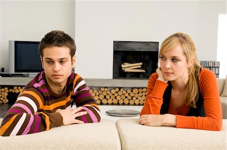 simsearch:6108-05863386,k - Young man leaning on a couch with a young woman looking at him Stock Photo - Premium Royalty-Free, Code: 6108-05860733