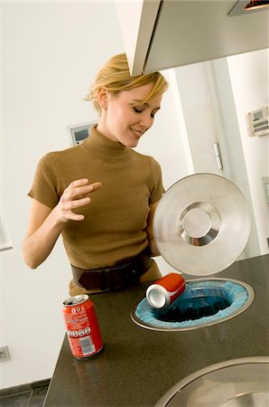 dustbin with waste material - Young woman putting a can into a garbage bin Stock Photo - Premium Royalty-Free, Code: 6108-05860811