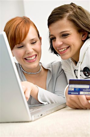 sweatshirt - Close-up of two young women holding a credit card and using a laptop Stock Photo - Premium Royalty-Free, Code: 6108-05861043