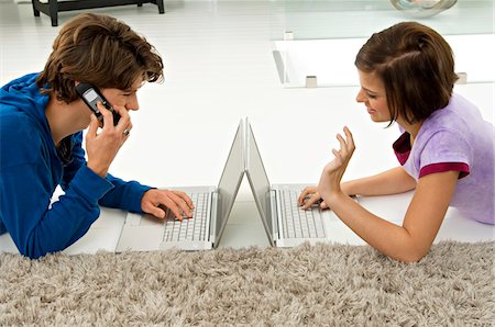 Teenage boy and a young woman using laptops Stock Photo - Premium Royalty-Free, Code: 6108-05861024