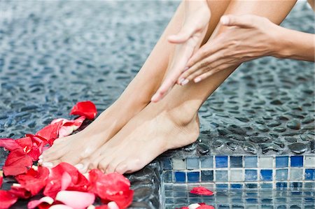 rubbing (massage) - Woman massaging her legs at the poolside Stock Photo - Premium Royalty-Free, Code: 6108-05861647