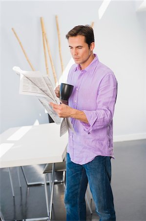 simsearch:6108-05856772,k - Man reading a newspaper and drinking a cup of coffee Stock Photo - Premium Royalty-Free, Code: 6108-05861884
