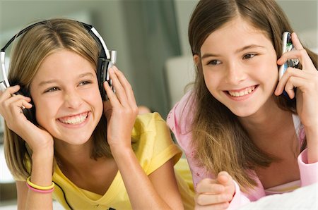 simsearch:6108-05857751,k - Girl talking on a mobile phone and her sister listening to headphones Stock Photo - Premium Royalty-Free, Code: 6108-05862330