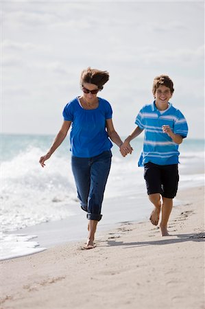 pictures of woman running with short hair - Woman running on the beach with her grandson Stock Photo - Premium Royalty-Free, Code: 6108-05862608