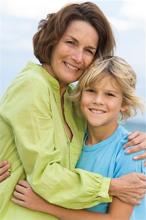 Woman smiling with her grandson on the beach Stock Photo - Premium Royalty-Free, Code: 6108-05862620