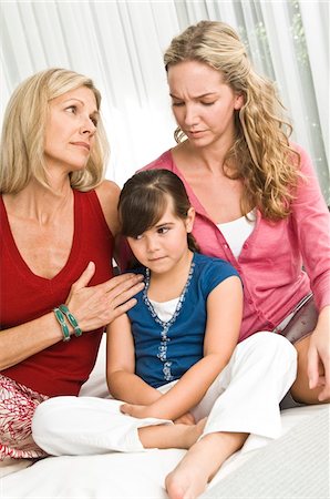 Girl sitting with her parents and looking sad Stock Photo - Premium Royalty-Free, Code: 6108-05862748