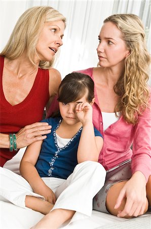 Girl sitting with her parents and looking sad Stock Photo - Premium Royalty-Free, Code: 6108-05862729