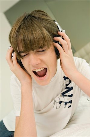 Boy listening to headphones Stock Photo - Premium Royalty-Free, Code: 6108-05862946