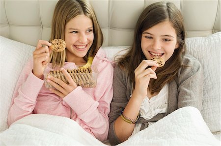 simsearch:6108-05865577,k - Two girls eating chocolate cookies Stock Photo - Premium Royalty-Free, Code: 6108-05862952