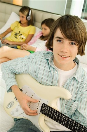 Portrait of a boy playing a guitar Stock Photo - Premium Royalty-Free, Code: 6108-05862980