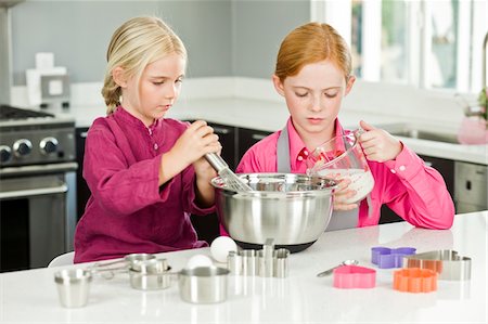 simsearch:6108-05869331,k - Two girls cooking food in the kitchen Stock Photo - Premium Royalty-Free, Code: 6108-05863049