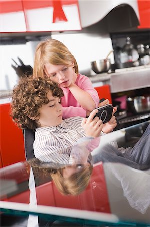 simsearch:6108-05863411,k - Boy playing a video game and his sister standing beside him Stock Photo - Premium Royalty-Free, Code: 6108-05863025