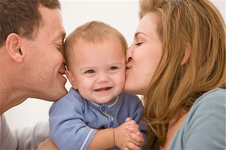 simsearch:6108-05863242,k - Parents s'embrasser leur fille Photographie de stock - Premium Libres de Droits, Code: 6108-05863193