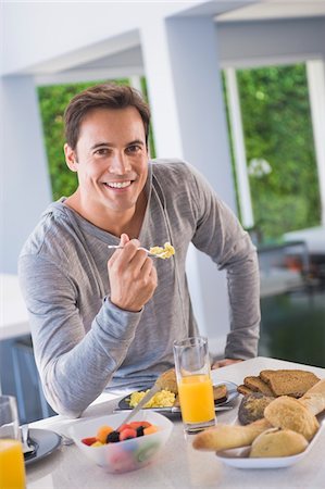 simsearch:6108-05864945,k - Portrait of a man having breakfast and smiling Stock Photo - Premium Royalty-Free, Code: 6108-05863244