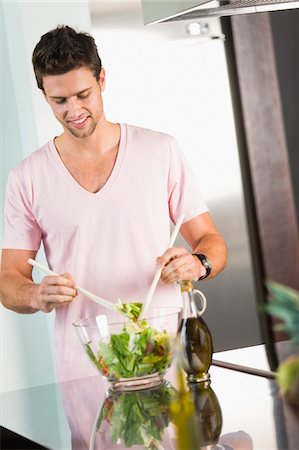 Man mixing vegetable salad in the kitchen Stock Photo - Premium Royalty-Free, Code: 6108-05863290