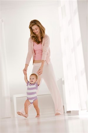 simsearch:6108-05860153,k - Woman helping her daughter to walk Stock Photo - Premium Royalty-Free, Code: 6108-05863220