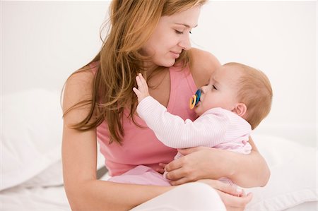 emotional images of mother holding baby - Woman carrying her daughter Stock Photo - Premium Royalty-Free, Code: 6108-05863239