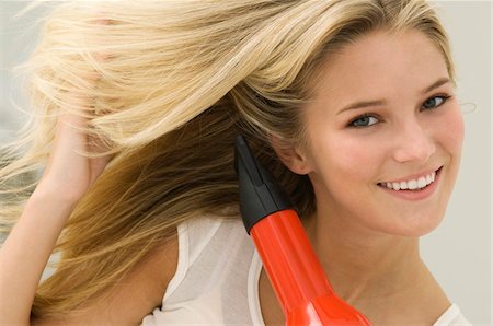 simsearch:6108-05863589,k - Woman drying her hair with a hair dryer Foto de stock - Sin royalties Premium, Código: 6108-05863556