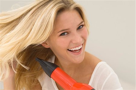 simsearch:6108-05863589,k - Woman drying her hair with a hair dryer Foto de stock - Sin royalties Premium, Código: 6108-05863562