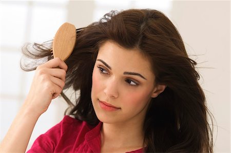 Close-up of a woman brushing her hair Stock Photo - Premium Royalty-Free, Code: 6108-05863586