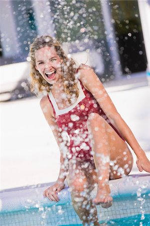 simsearch:6108-05861651,k - Woman sitting at the poolside and splashing water Stock Photo - Premium Royalty-Free, Code: 6108-05863774