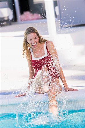 simsearch:6108-05861651,k - Woman sitting at the poolside and splashing water Stock Photo - Premium Royalty-Free, Code: 6108-05863797