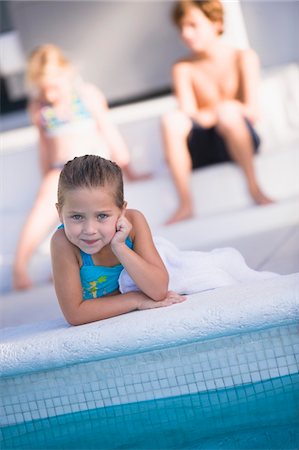 simsearch:6108-05863846,k - Portrait d'une jeune fille se trouvant à bord de la piscine et souriant Photographie de stock - Premium Libres de Droits, Code: 6108-05863799