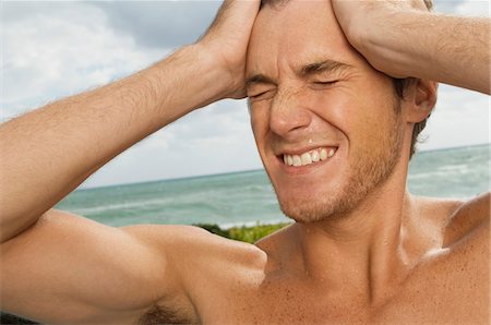 face front man - Homme tenant sa tête dans la douleur sur la plage Photographie de stock - Premium Libres de Droits, Code: 6108-05863865