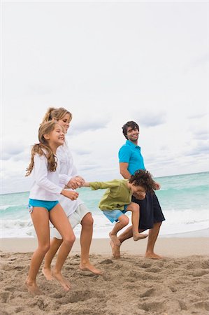 Family running on the beach Stock Photo - Premium Royalty-Free, Code: 6108-05864041